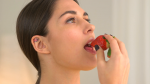 woman-enjoying-eating-strawberry_ekytwumfg__F0000