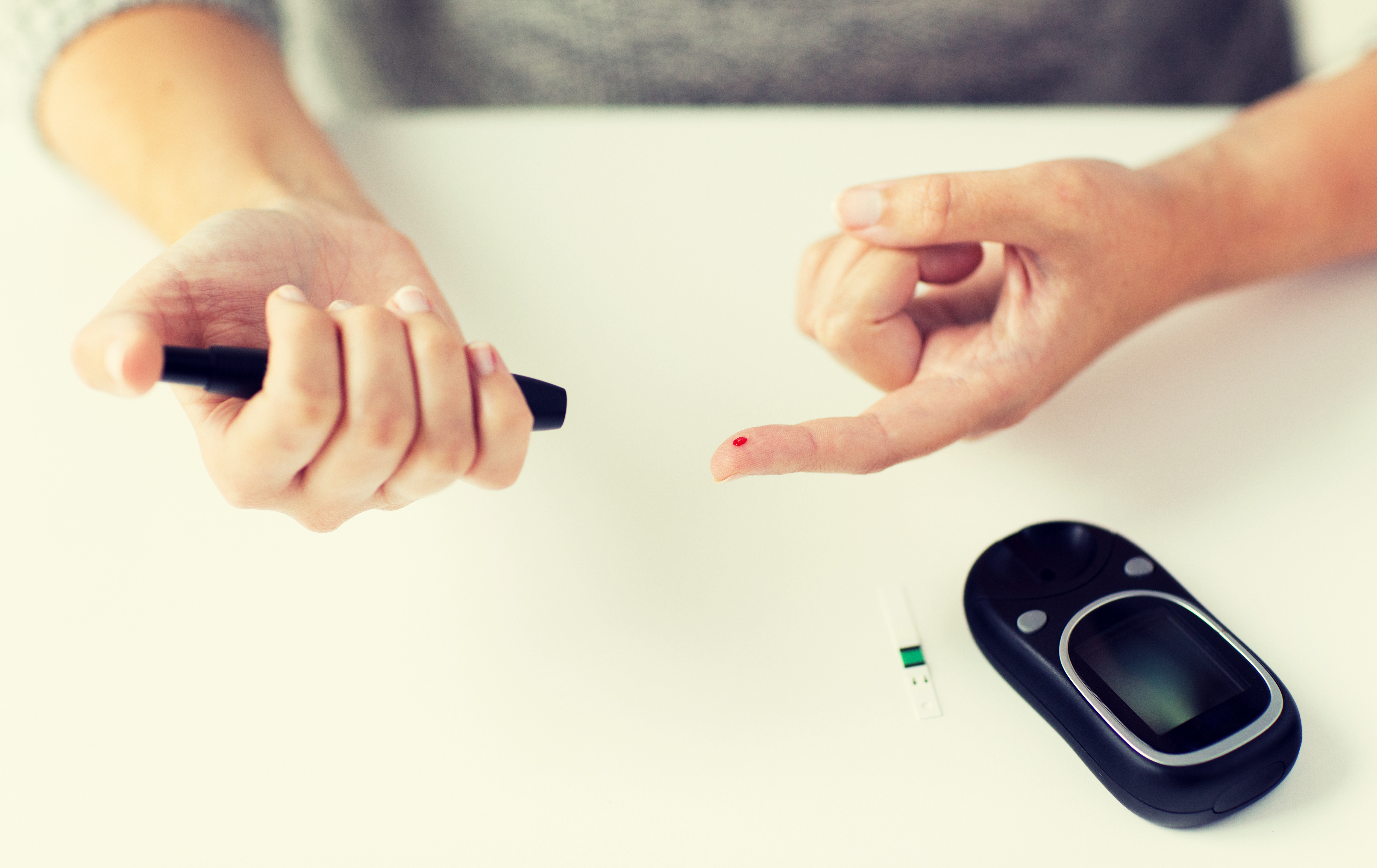 close up of woman making blood test by glucometer