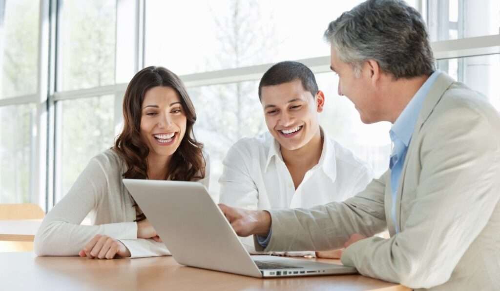 three individuals in a focused discussion, illustrating the vital role of ESG consultant in aligning business goals for profit and purpose.