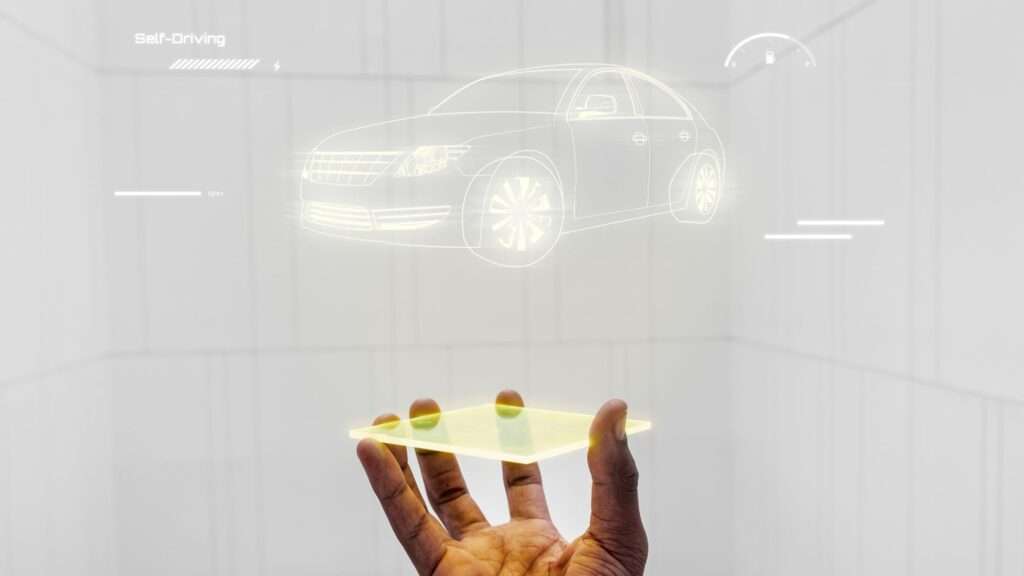 A hand holding a tablet displaying a Mazda 3 MPS car automotive technology